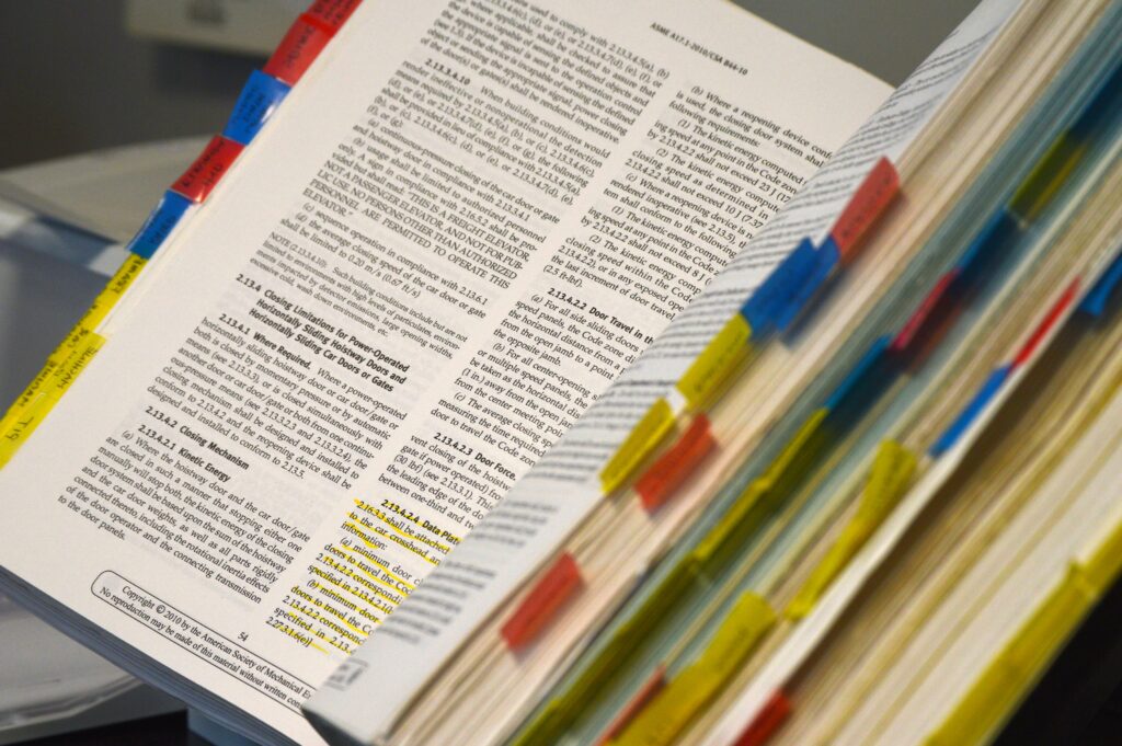 A thick manual, an example of technical writing, sits open with many tabs and highlights.